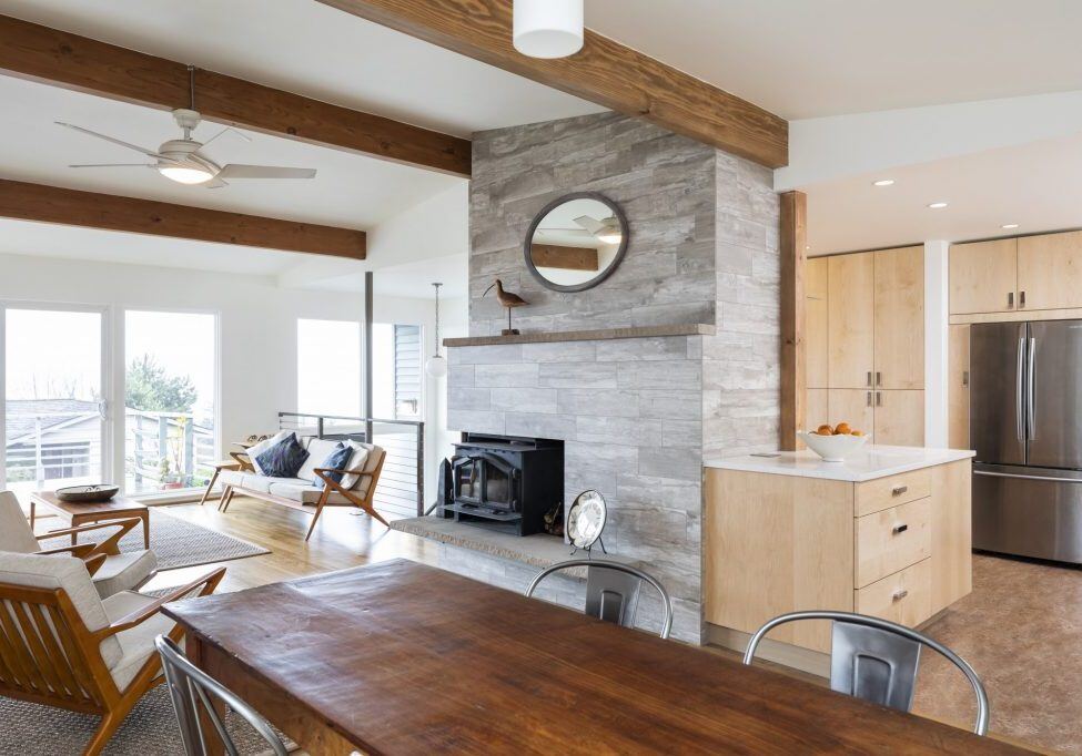 home remodel in seattle with open layout, exposed ceiling beams, and stone fireplace